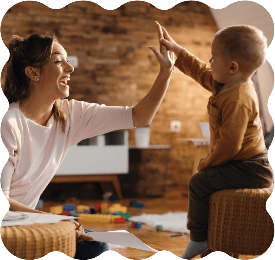A caregiver and child sharing a high five